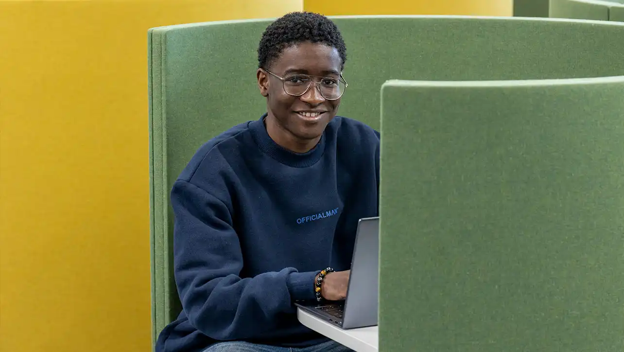 Smiling University of Southampton student sitting with laptop