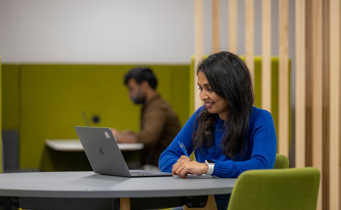 Female Southampton student smiling and working on a laptop
