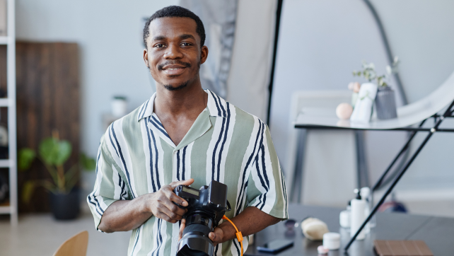 Male content creator holding a camera
