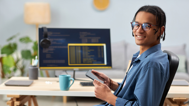 Smiling AI professional sitting at a desk with a computer