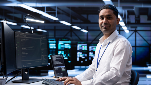 Smartly dressed AI professional sitting in front of a computer screen