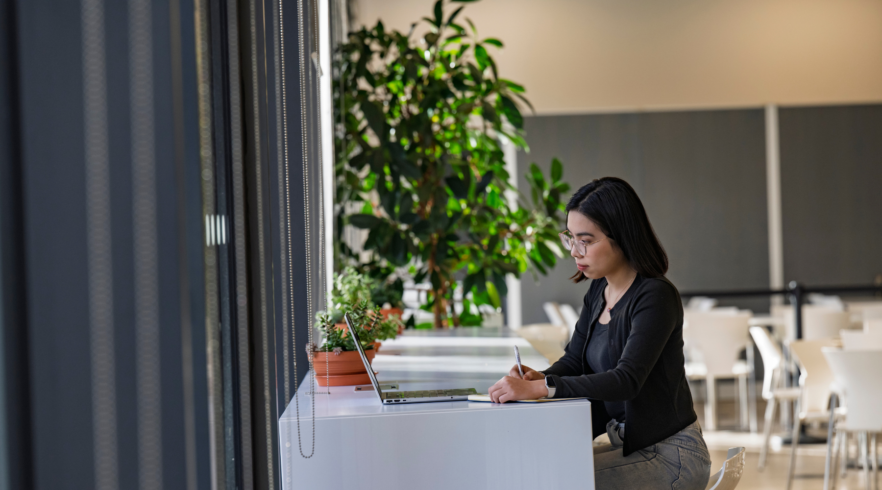 Student working on a laptop at a table in a study space.