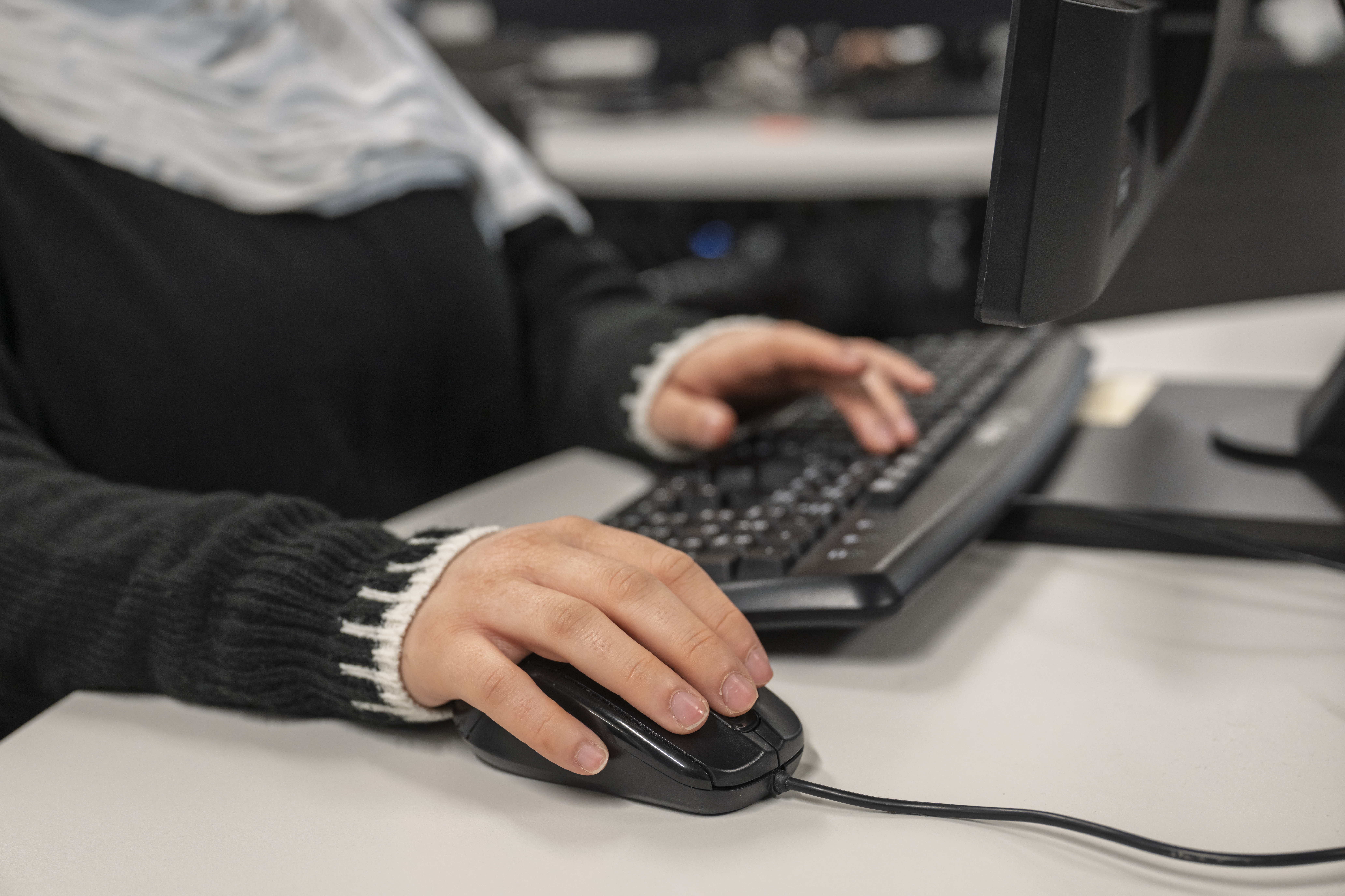 Close-up of student using a mouse and keyboard